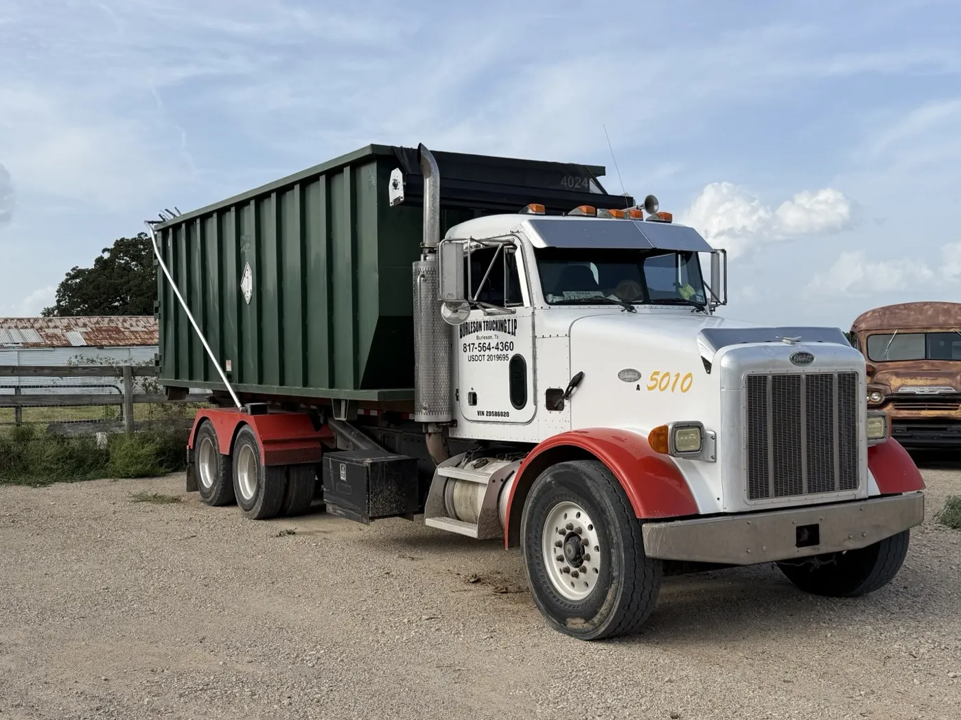 Roll-off truck carrying a dumpster to a job